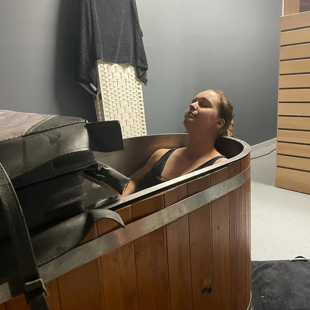 A woman relaxing in the ice bath at Revive Hub