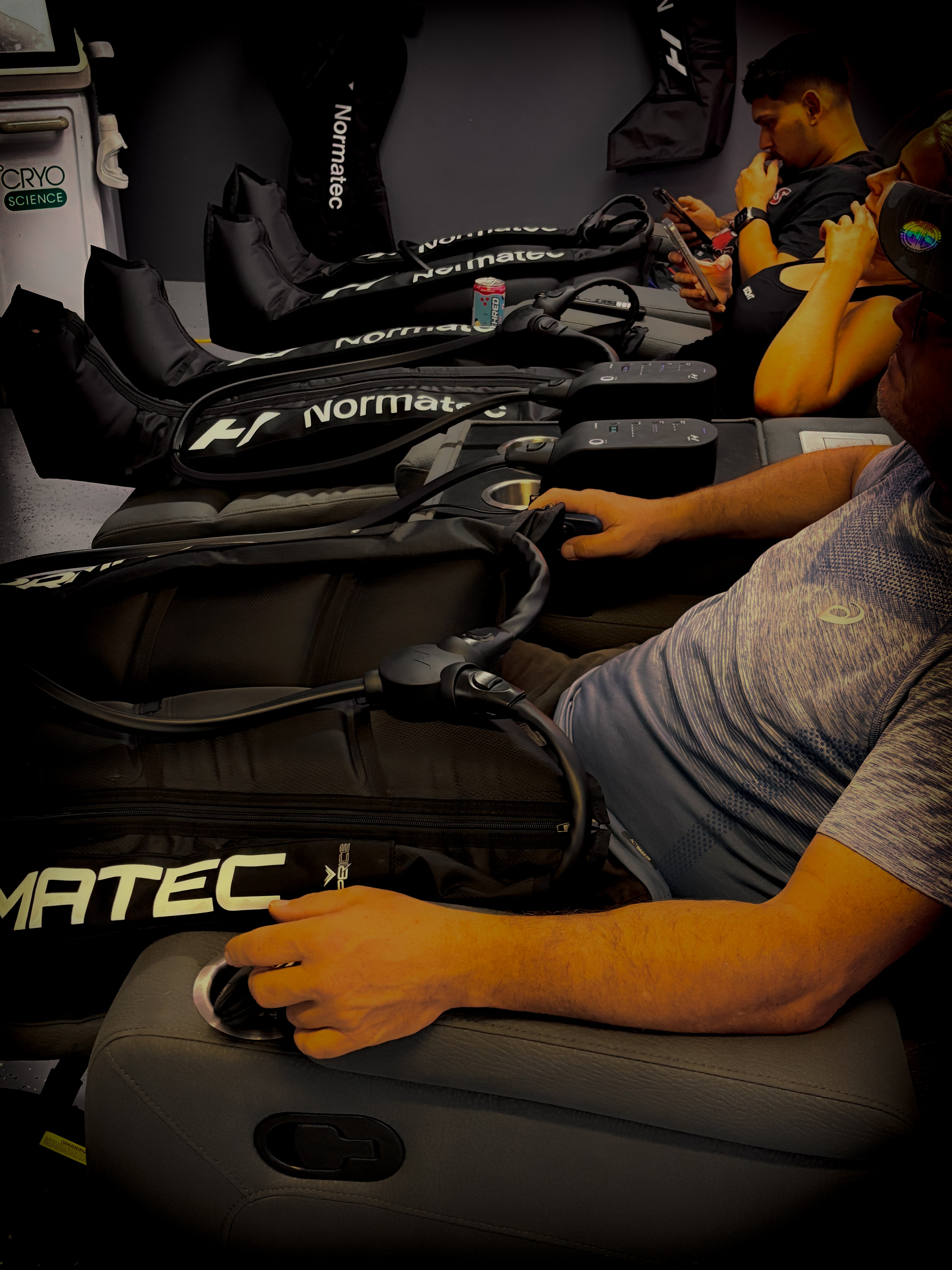 A group using Normatec compression boots at Revive Hub